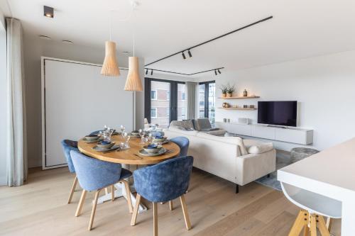 a living room with a table and chairs and a couch at De Branding A21 in Cadzand
