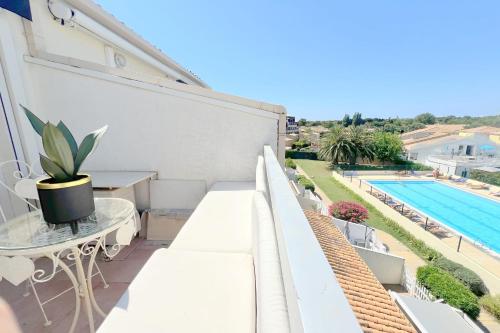 Il dispose d'un balcon doté d'un mobilier blanc et d'une piscine. dans l'établissement Naturiste Cap d'Agde Port Soleil 482, au Cap d'Agde