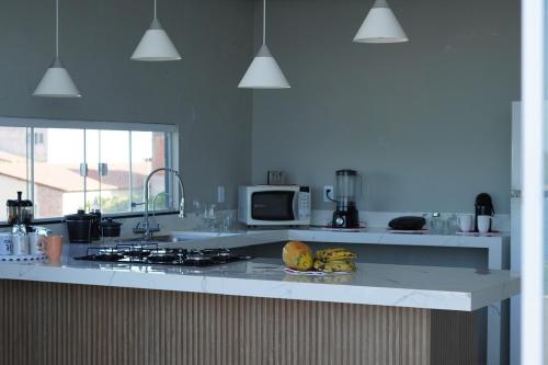 a kitchen with a stove and a plate of fruit on a counter at Apartamento Lagoa do Paraiso - Jericoacoara in Jijoca de Jericoacoara