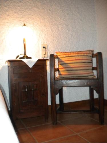 a chair with a pillow and a lamp on a table at Agrampeli in Méga Khoríon