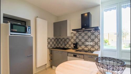 une cuisine avec un évier et une cuisinière four supérieur dans l'établissement Le Sancy, à Montaigut-le-Blanc