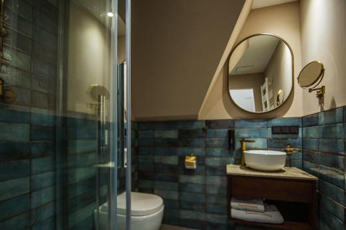a bathroom with a toilet and a sink and a mirror at Hotel Ratsmühle Lüneburg in Lüneburg