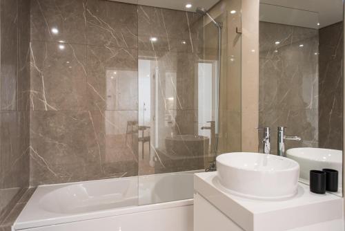a bathroom with a white sink and a shower at The Haus - Santa Bárbara II in Lisbon