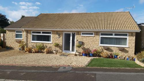 a brick house with plants in front of it at Meadow View in Chalford