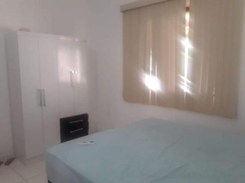 a white room with a bed and a window at Casa dos Maias in Valença