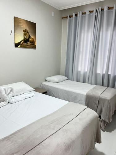 a room with two beds and a picture on the wall at STILLO AÇAI in Bragança