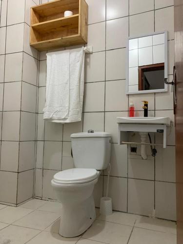 Un baño con un inodoro blanco y un espejo. en Lumena résidence, en Abiyán