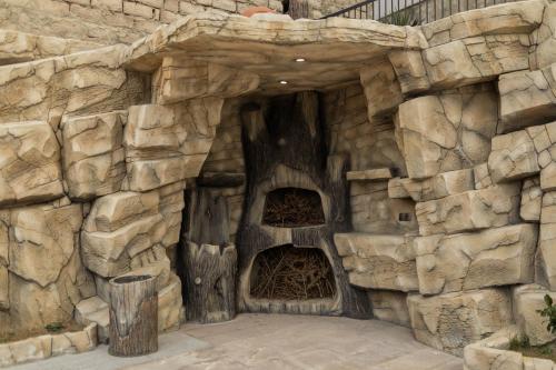 a large stone wall with a large wooden structure at Panorama Hills Apart-Hotel in Tbilisi City