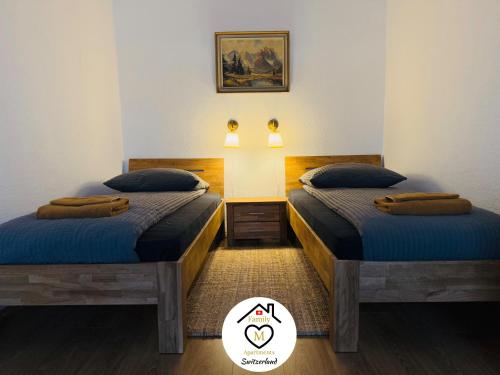 two twin beds in a room with a picture on the wall at Family M Apartments 2 in Kappel bei Olten