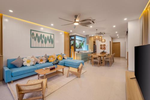 a living room with a blue couch and a table at Amazing Newly Built Beach Pool Villas Danang in Da Nang