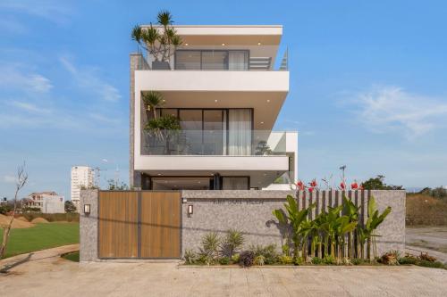 a large white house with a fence in front of it at Amazing Newly Built Beach Pool Villas Danang in Da Nang