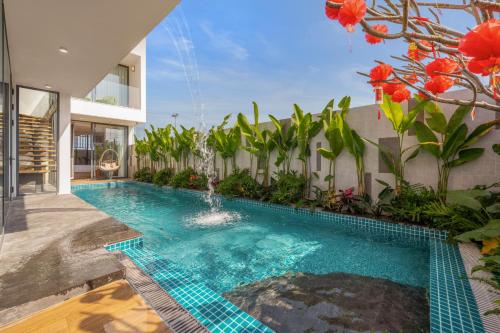 a swimming pool in front of a building at Amazing Newly Built Beach Pool Villas Danang in Da Nang