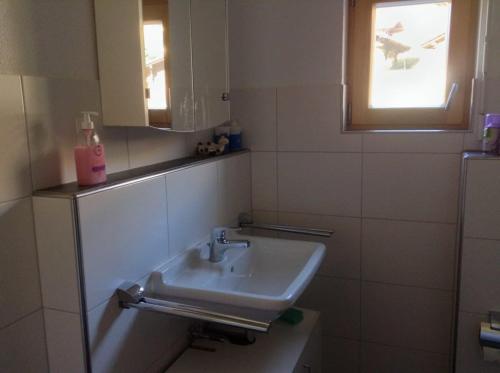 Un baño con lavabo y ventana. en Gorgeous Chalet in Truttli Area of Lauenen, en Lauenen