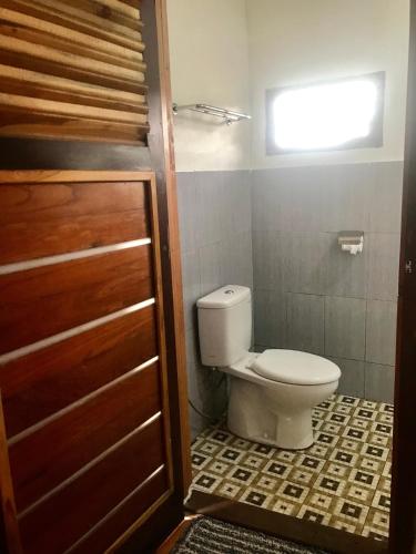 a bathroom with a toilet and a window at Pesona 361 Alam Bungalows in Rarang