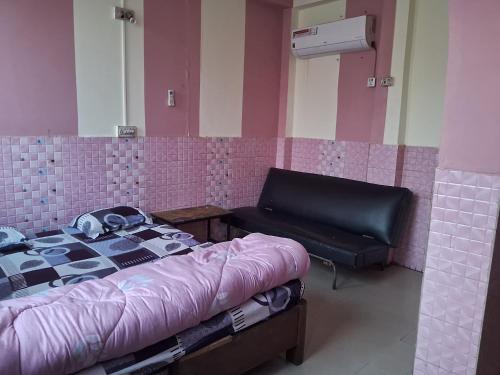 a room with a bed and a bench and a mirror at Hotel Shah Paradise in Bīrganj