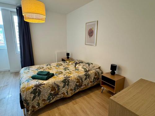 - une chambre avec un lit et une table avec une table de chevet dans l'établissement T3 hyper centre, à Valence
