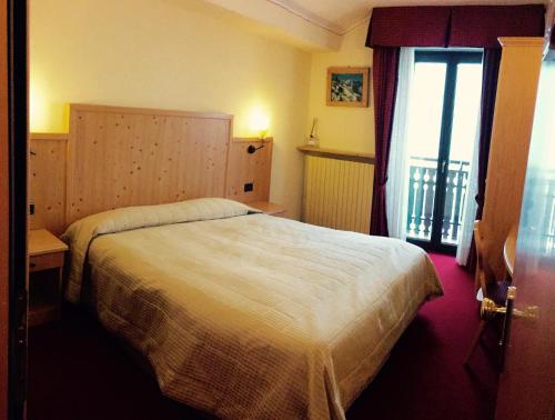a hotel room with a bed and a window at Hotel Ristorante Miramonti in Val Masino