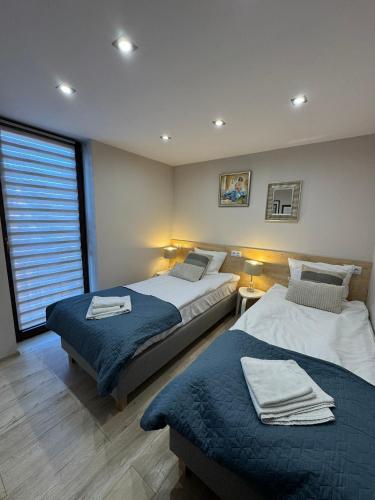 a bedroom with two beds and a window at Aparthotel Riva in Zawiercie
