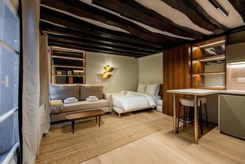 un salon avec un canapé et un lit dans l'établissement Studio 2pers # Île St Louis # Bord de Seine, à Paris