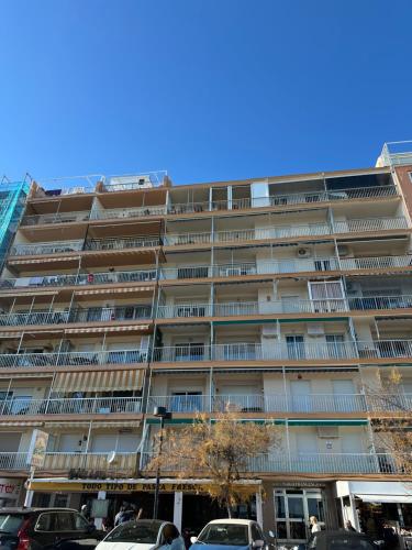 an apartment building with cars parked in front of it at Horizonte 3 Charming apartment with breathtaking sea view at first line of Fuengirola beach in Fuengirola