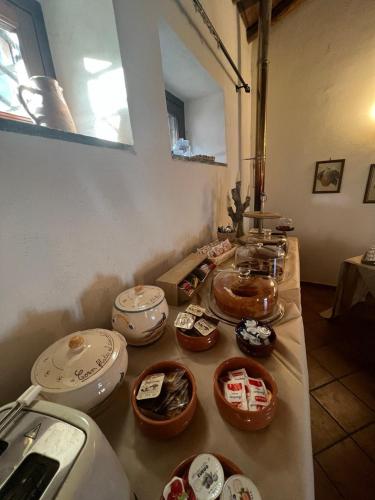 a table with many bowls and plates on it at Le Case Del Merlo Turismo Rurale in Milo