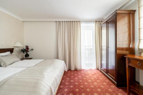 a hotel room with a bed and a window at Coco Boutique Hotel & Spa in Karpacz