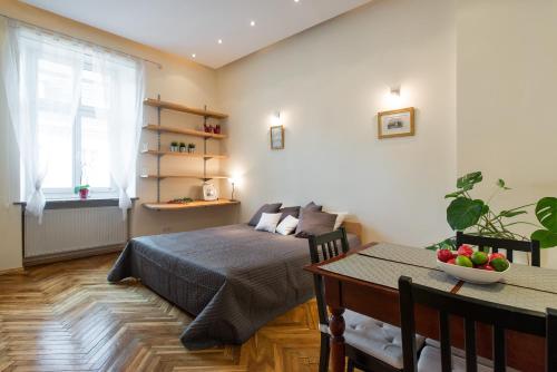 a bedroom with a bed and a table with a bowl of fruit at Urban Studio Apartment in Krakow