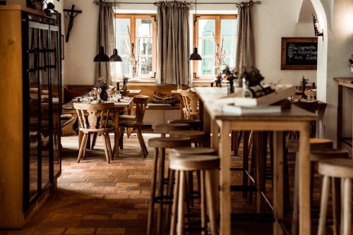 a room with tables and chairs and a kitchen with windows at Hotel Stiegl-Gut Wildshut in Wildshut
