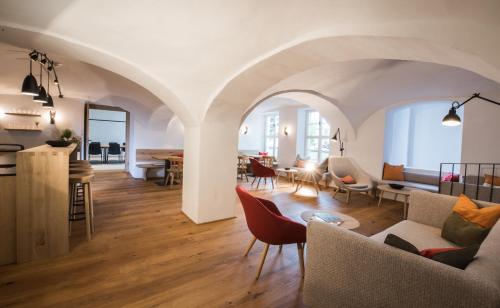 a living room with white walls and wooden floors at Hotel Stiegl-Gut Wildshut in Wildshut