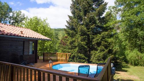 - un bain à remous sur une terrasse à côté d'une cabine dans l'établissement Le Chalet des Berges - Piscine chauffée & Ponton Privé - En bordure de la rivière Aveyron, à Saint-Antonin
