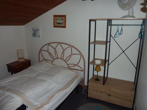 une chambre avec un lit et une étagère dans l'établissement LE COURANT D'HUCHET, à Moliets-et-Maa