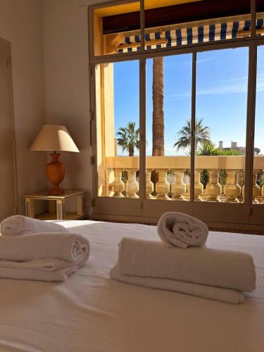 - une chambre avec 2 serviettes sur un lit et une fenêtre dans l'établissement Appartement 4 couchages vue mer Parc Continental, à Cannes