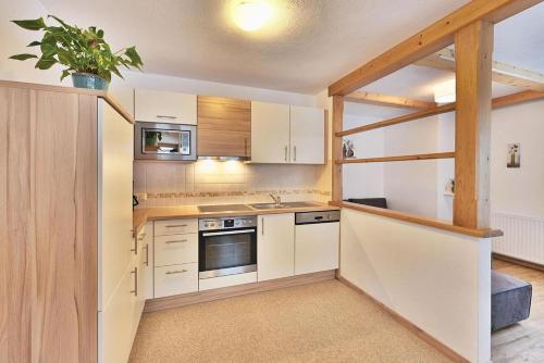 a kitchen with white cabinets and a potted plant at Haus Oberluggauer in Wald am Arlberg