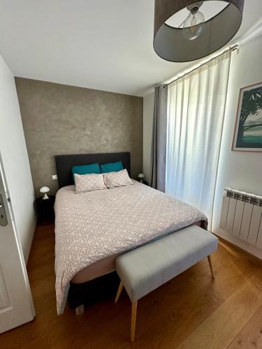 une chambre avec un lit et une grande fenêtre dans l'établissement Bel appart, le petit Carnot, à Annecy