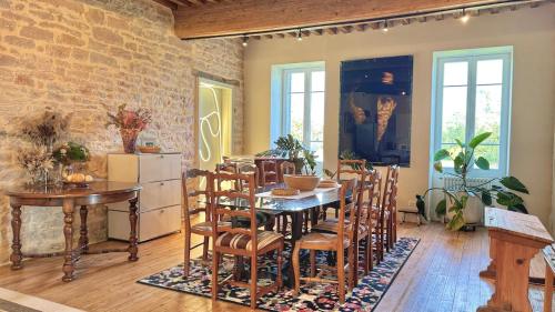 d'une salle à manger avec une table, des chaises et un mur en briques. dans l'établissement La Casa Do - Havre de Paix au Bord de L'eau, à Cuisery