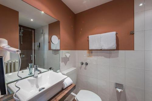 a bathroom with a white sink and a toilet at PANORAMA HOTEL in Neustadt an der Weinstraße in Neustadt an der Weinstraße