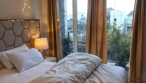 a bedroom with a bed and a large window at Luxus Gold Villa DHA Near Airport & Raya in Lahore