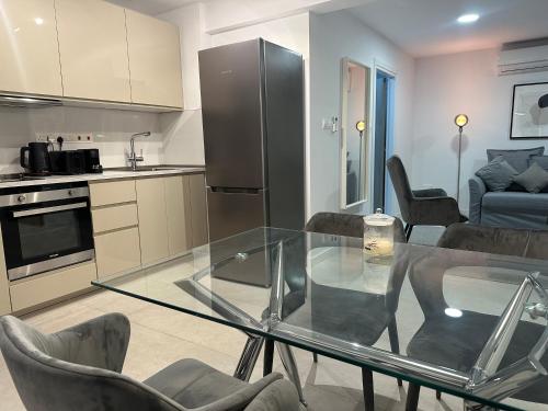a kitchen with a glass table and chairs in a room at Melia Suites in Limassol
