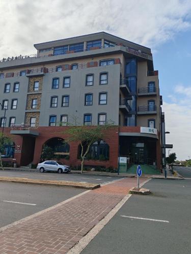 a large building with a car parked in front of it at Regal Inn Umhlanga Gateway in Durban