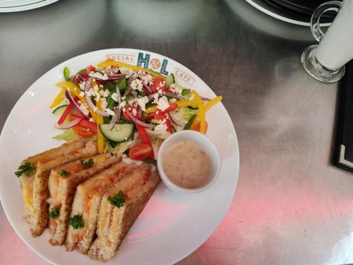 a plate of food with a sandwich and a salad at Regal Inn Umhlanga Gateway in Durban