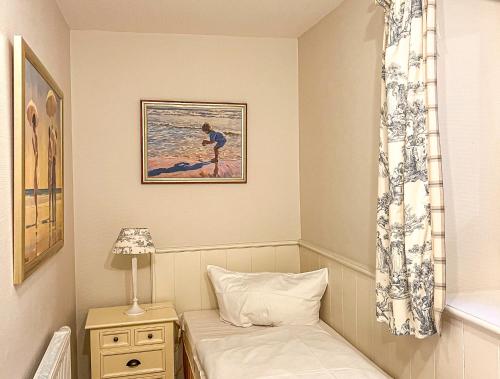a bedroom with a bed and a picture of a surfer at Landhaus auf der Düne, App 2 in Rantum