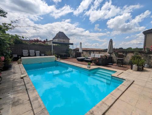 une piscine avec de l'eau bleue dans une cour arrière dans l'établissement La Maison Anglaise, à Monpazier