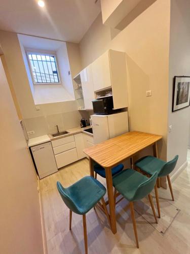 une petite cuisine avec une table en bois et deux chaises dans l'établissement Studio Le Parc Continental Cannes, à Cannes
