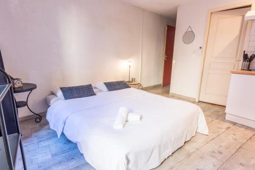 - une chambre avec un grand lit blanc et une chaise dans l'établissement Résidence St Vincent, à Collioure