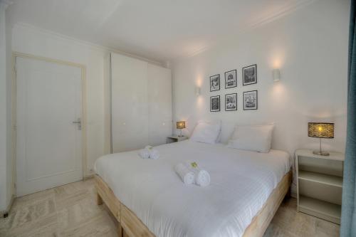 - une chambre avec un lit blanc et 2 serviettes blanches dans l'établissement Immogroom - cosy apartment - Terrace - AC - Wifi, à Cannes