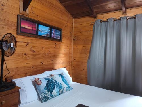 a bedroom with a bed and a tv on the wall at Tiny House Novas Palmeiras in Florianópolis