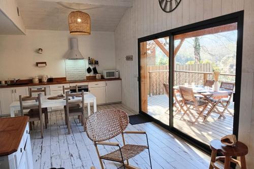 une cuisine et une salle à manger avec une table et des chaises dans l'établissement Wooden lodge with garden, à Vielle-Saint-Girons