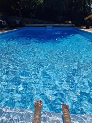 une personne dormant dans une piscine bleue dans l'établissement Le relais des clefs -Piscine chauffée, pétanque - 8pers, à Valpuiseaux