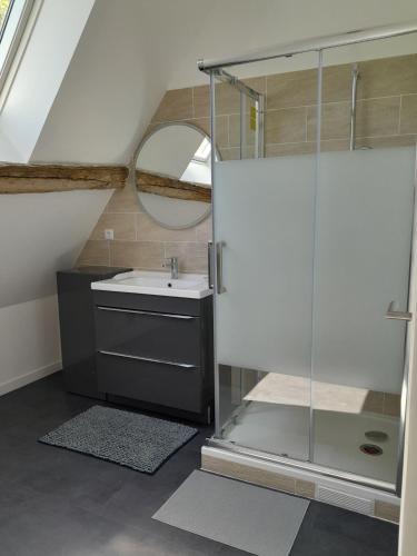 une salle de bain avec un lavabo et un miroir dans l'établissement Chaleureuse longère familiale 3 étoiles, à Pellevoisin