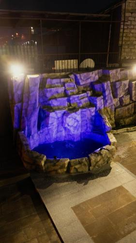 a stone wall with a blue pool of water at Panorama Hills Apart-Hotel in Tbilisi City
